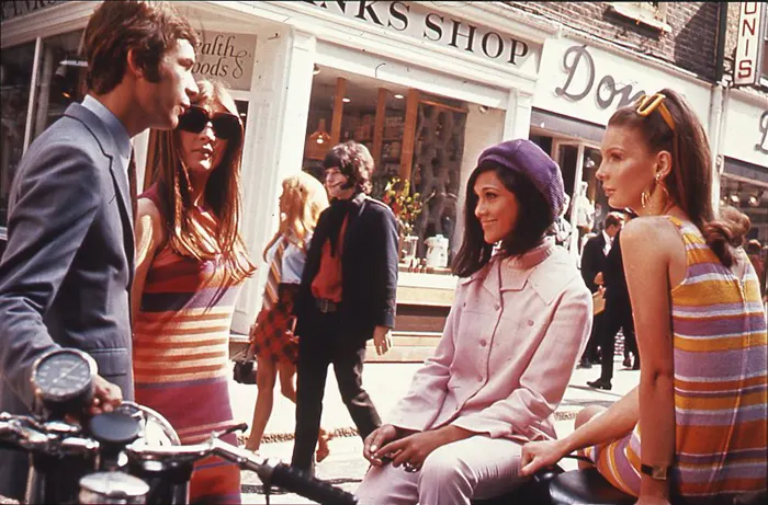 Young adults on Carnaby Street during the height of Swinging London, captured around 1966 when the street became a global symbol of youth culture and fashion.