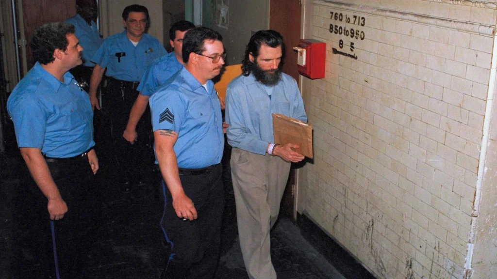 Gary Heidnik, right, is escorted from a holding cell in Philadelphia after a jury convicted him of first degree murder.