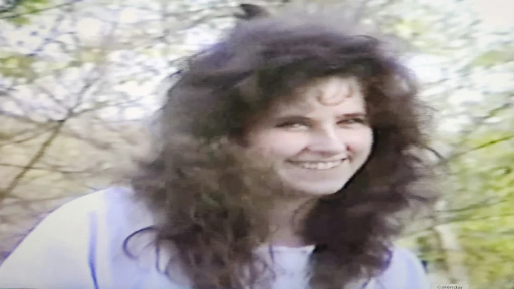 Close-up photograph of Heather Teague smiling outdoors against a blurred background of trees.