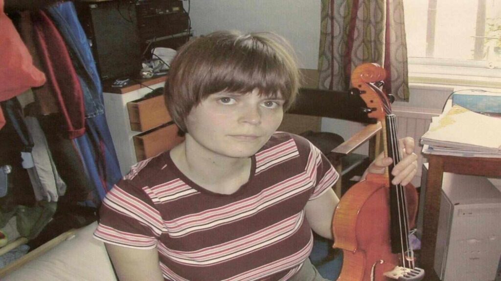 Jane Longhurst posing for a photograph while holding a viola.