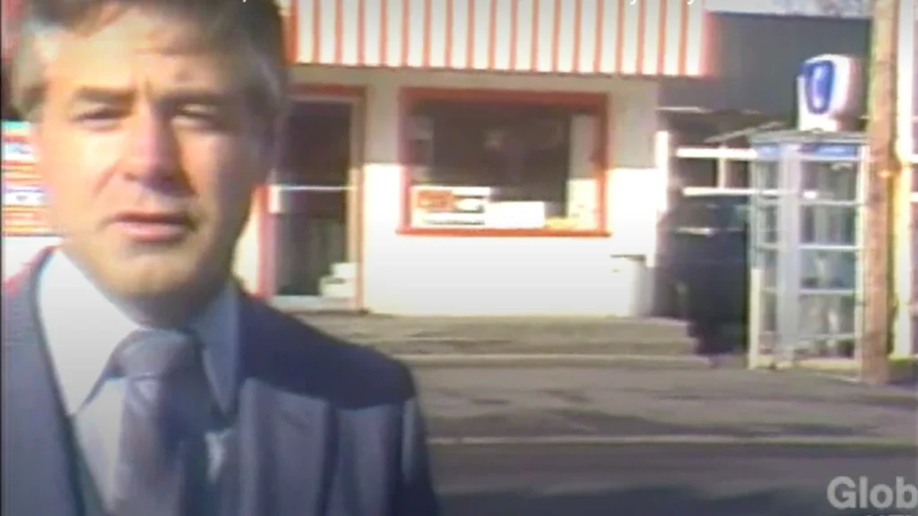 Reporter John L. Daly stands outside the Penny Pincher convenience store during a 1983 news broadcast, with the glass payphone booth where Jo-Anne Pedersen was last seen visible behind him.

