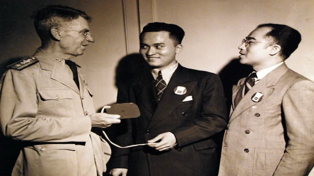 Rear Admiral Julius Furer presenting Poon Lim with a signaling mirror after Lim survived months alone on a raft in the South Atlantic.