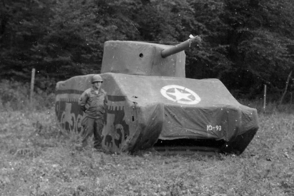 A soldier from the 'Ghost Army' poses with an inflatable M4 Sherman Tank. Photo courtesy of the United States National Archives.