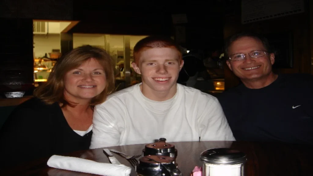 Bryce Laspisa sitting at a restaurant table between his parents, Karen and Michael Laspisa.