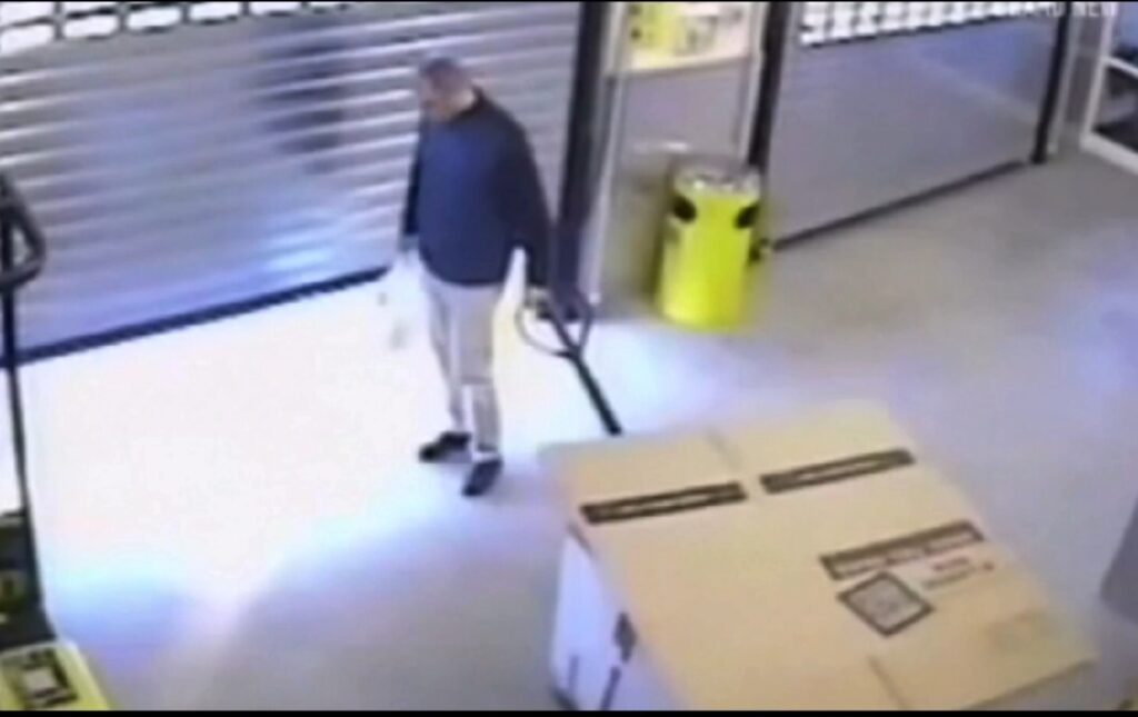 Graham Coutts pushing a large box on a trolley outside a storage facility.