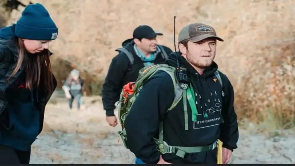 Volunteer searchers navigate rugged outdoor terrain during a community-led search operation for Ryan Shtuka.