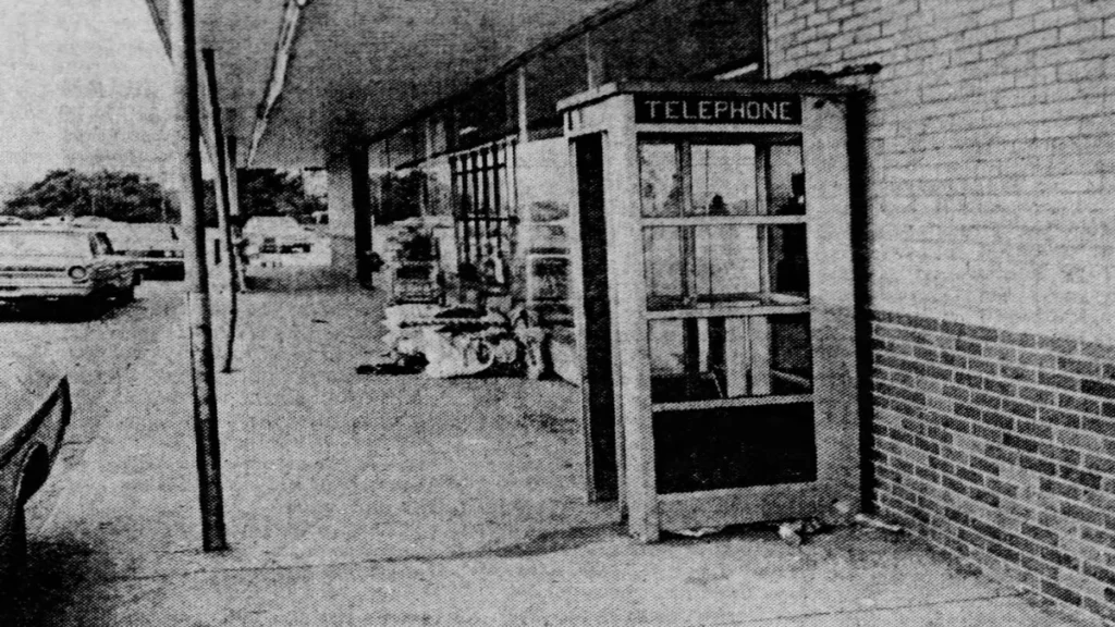 A black-and-white newspaper archival photograph showing the vintage glass public telephone booth located outside the A&P Supermarket storefront in Lumberton, New Jersey