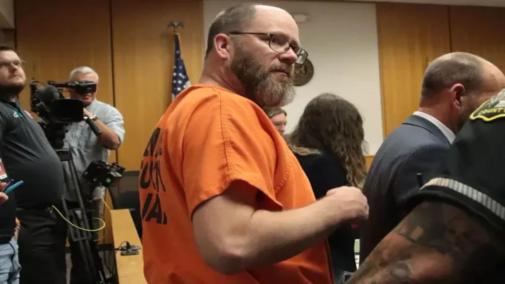 Dale Warner wearing an orange jail uniform inside a Lenawee County courtroom.