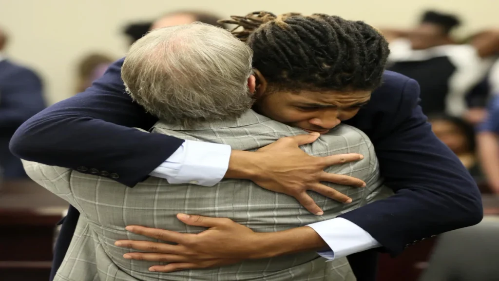 Former Virginia Tech football player Isimemen David Etute hugs his defense attorney Jimmy Turk after closing arguments in his trial in Montgomery County Circuit Court in Christiansburg