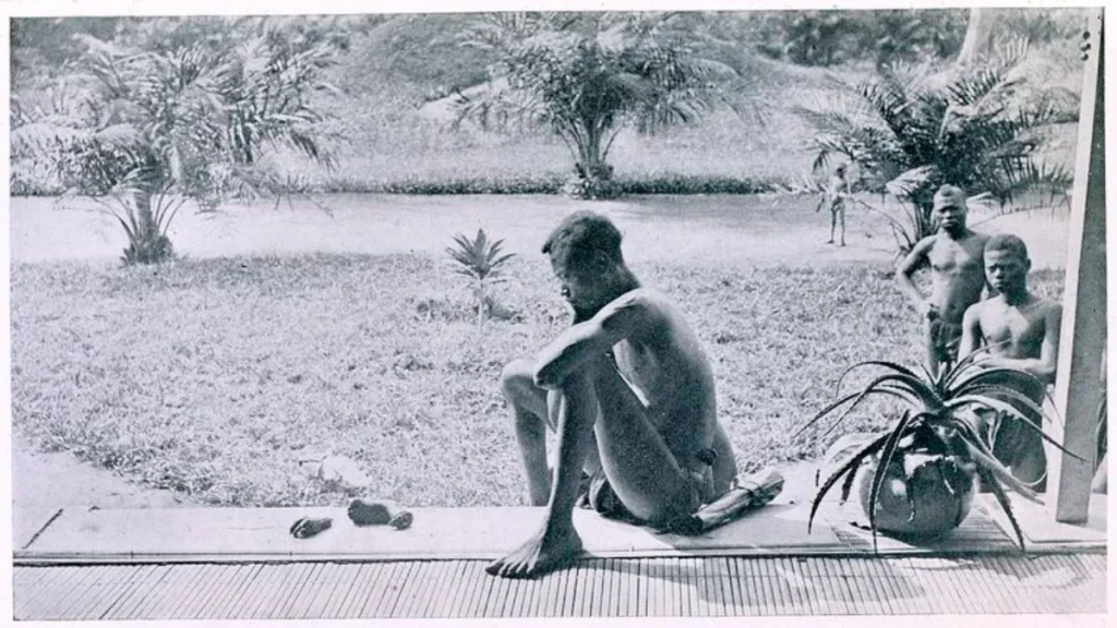 Nsala of Wala seated beside the severed hand and foot of his daughter Boali in a 1904 photograph from the Congo Free State.