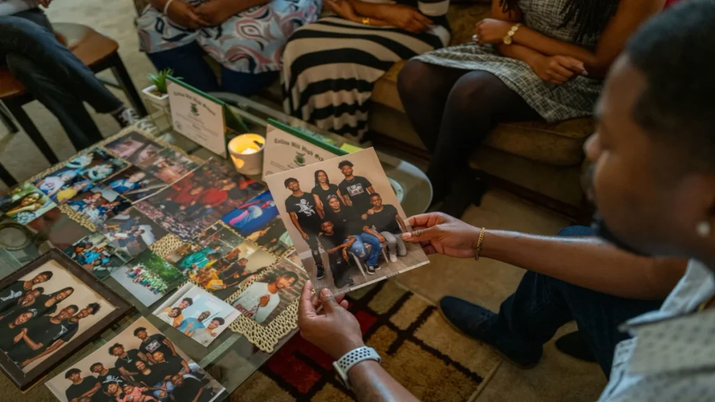 Rahim Brawner holding a family photo of Qaadir and Naazir Lewis.