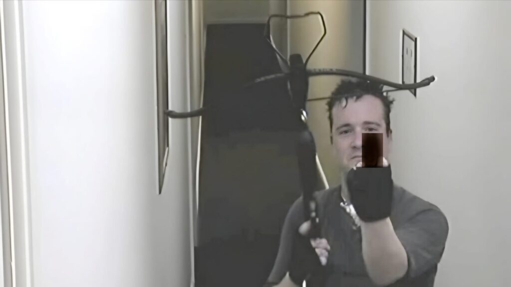 Stephen Griffiths defiantly points his crossbow at the CCTV Camera with a lewd gesture.