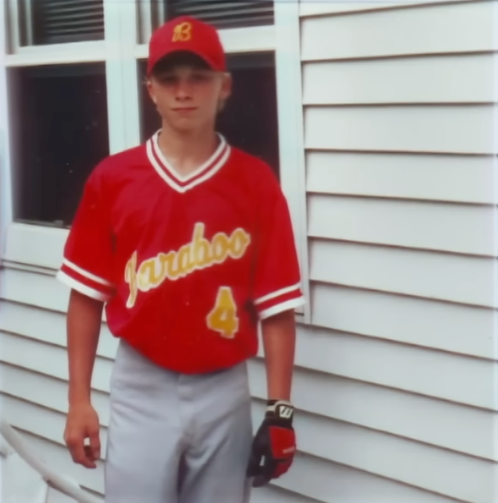 Young Thad Phillips wearing a red Baraboo baseball uniform and cap, with the number 4 on his jersey, shortly after joining the Baraboo White team.
