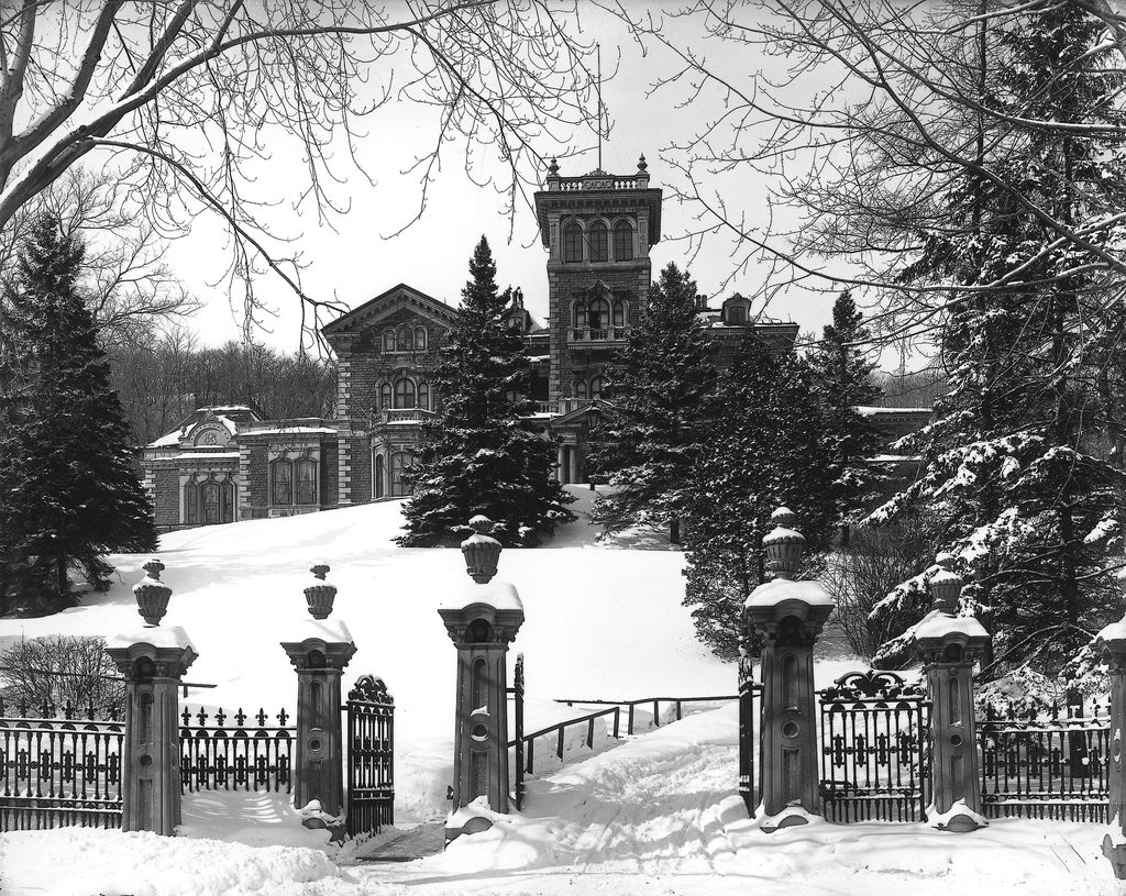 Ravenscrag’s stone mansion and central tower behind snow-covered grounds and ornate iron gates in 1901.