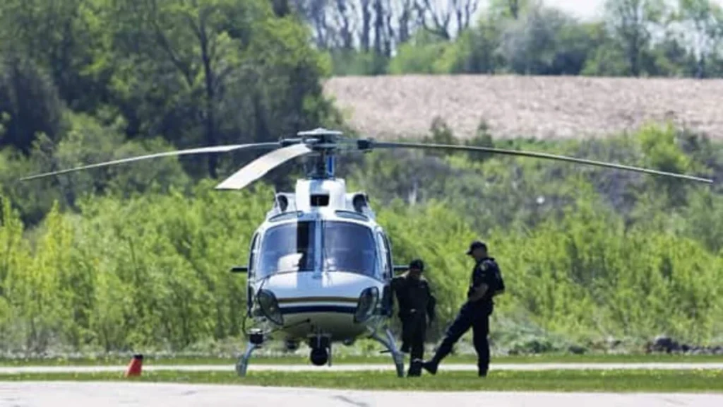 Ontario Provincial Police officers in Guelph, Ont., prepare to take off in a helicopter to search for eight-year-old Victoria Stafford's body on Thursday.