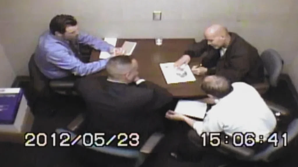 During questioning, Pedro Hernandez, far right, is seen signing Etan Patz's missing poster.